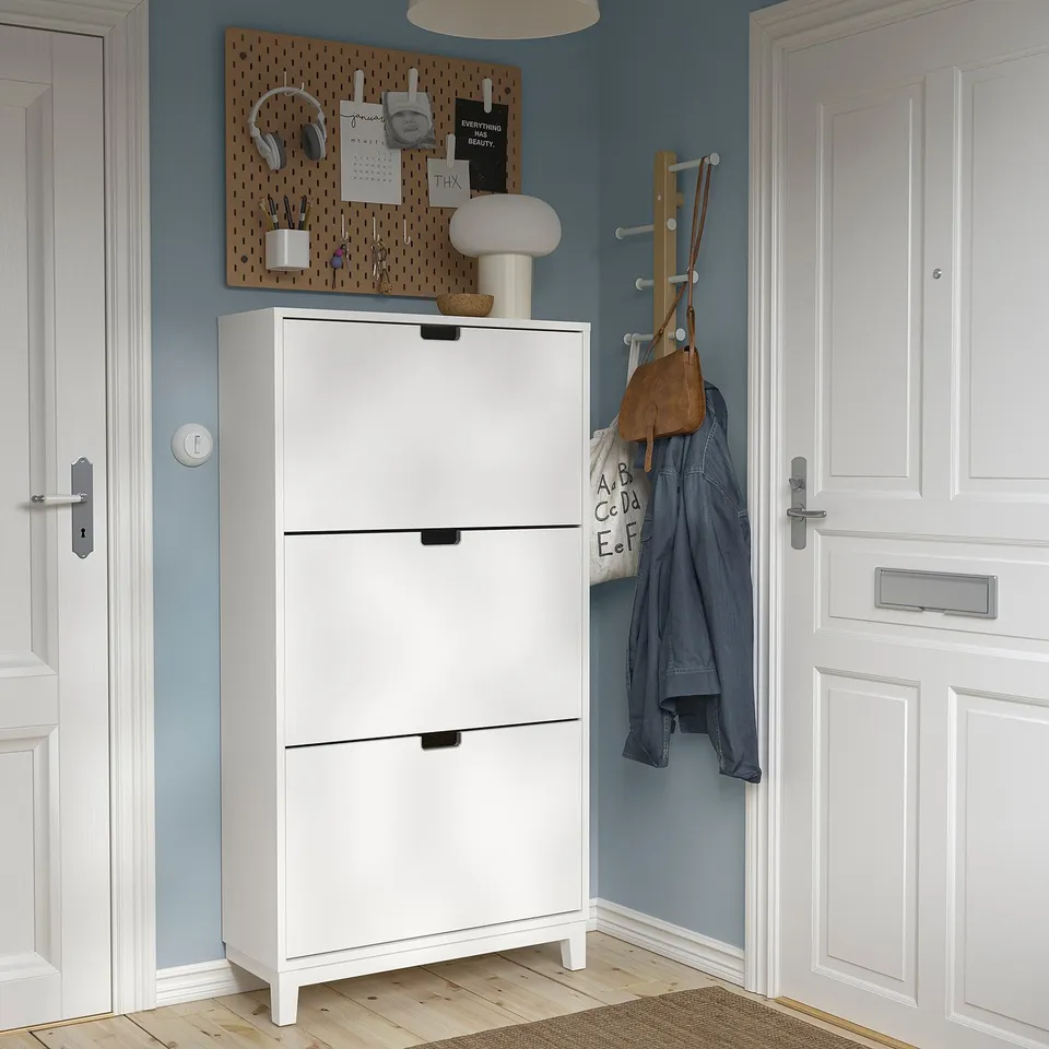 White STÄLL shoe cabinet, wooden floor, blue wall, next to white doors.