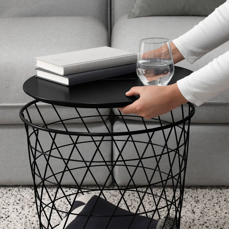 Person with wine glass, modern side table & books.