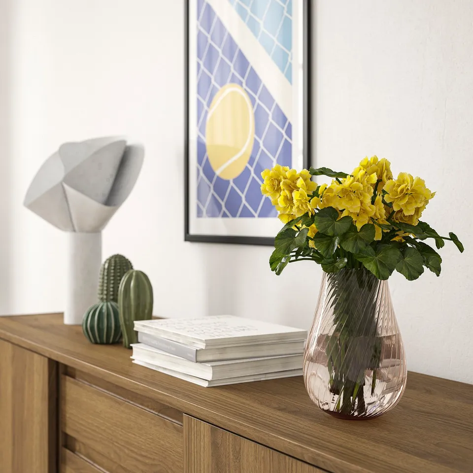 Modern glass vase PÅSKÖTRÄD with yellow flowers.