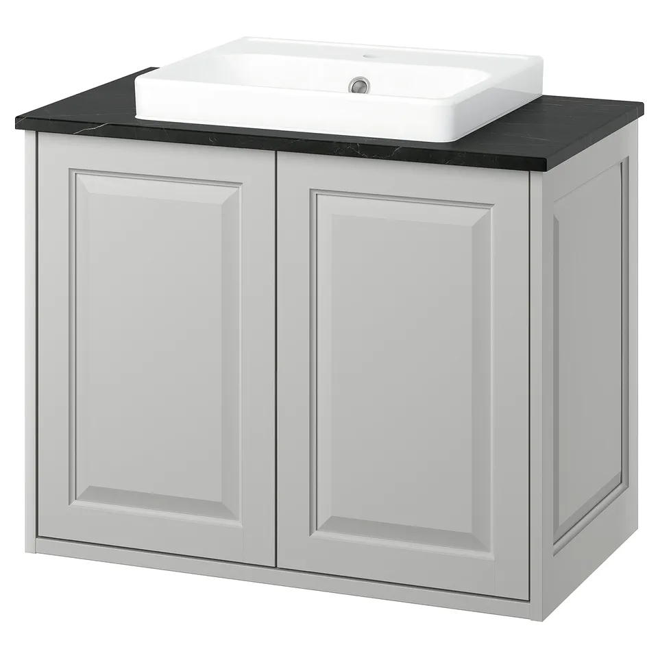 TÄNNFORSEN light grey bathroom cabinet with black marble countertop and white sink.