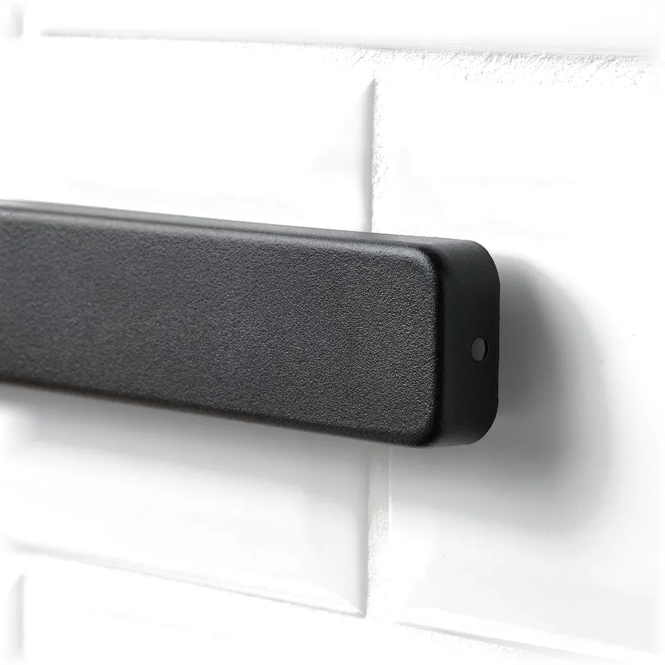 Close-up of sleek magnetic knife holder, mounted on white tiled wall, showcasing smooth dark finish and sturdy design.
