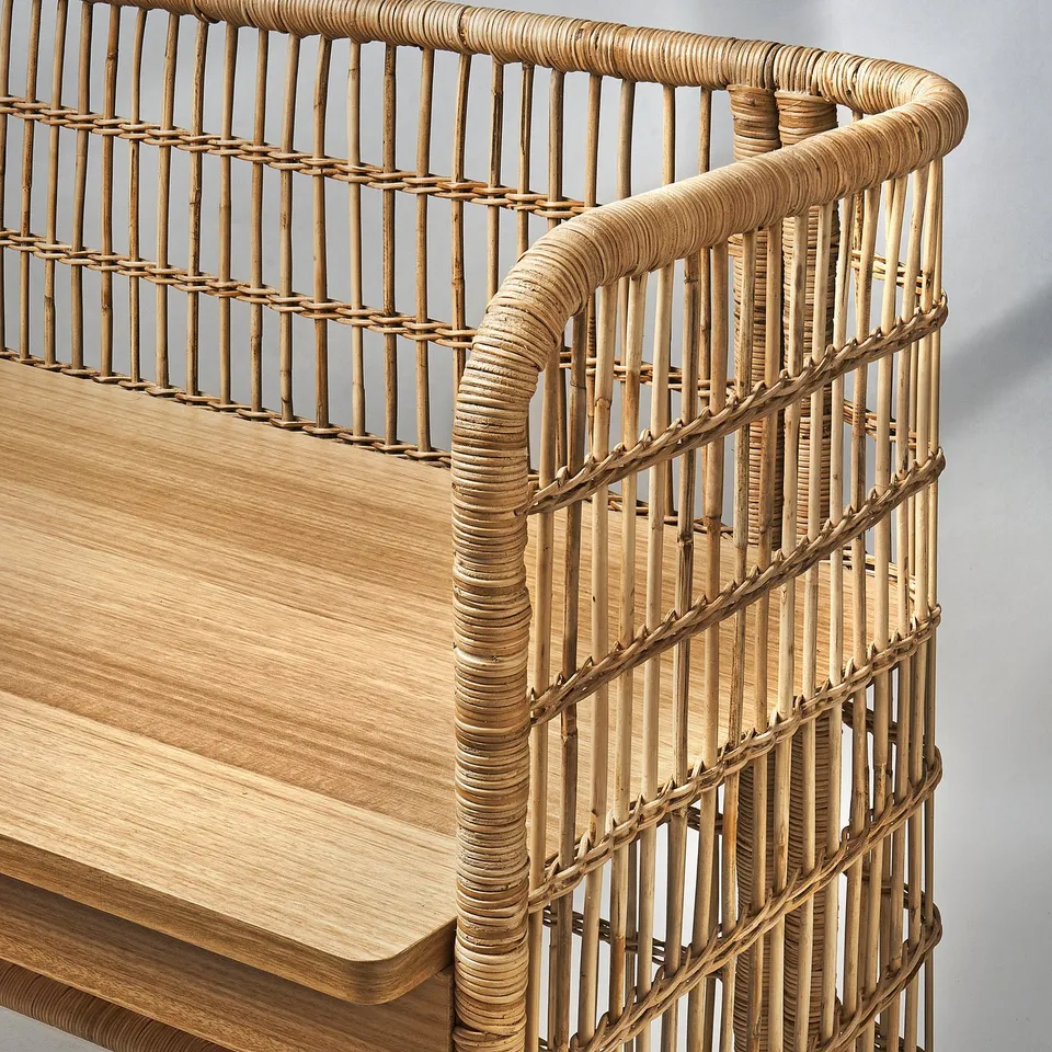 Wicker table corner with thick, natural wood slats and intricately woven design, showcasing high-quality craftsmanship and durability.