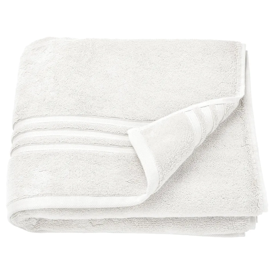 BROKGLIM white organic cotton towels, folded neatly with a decorative border.