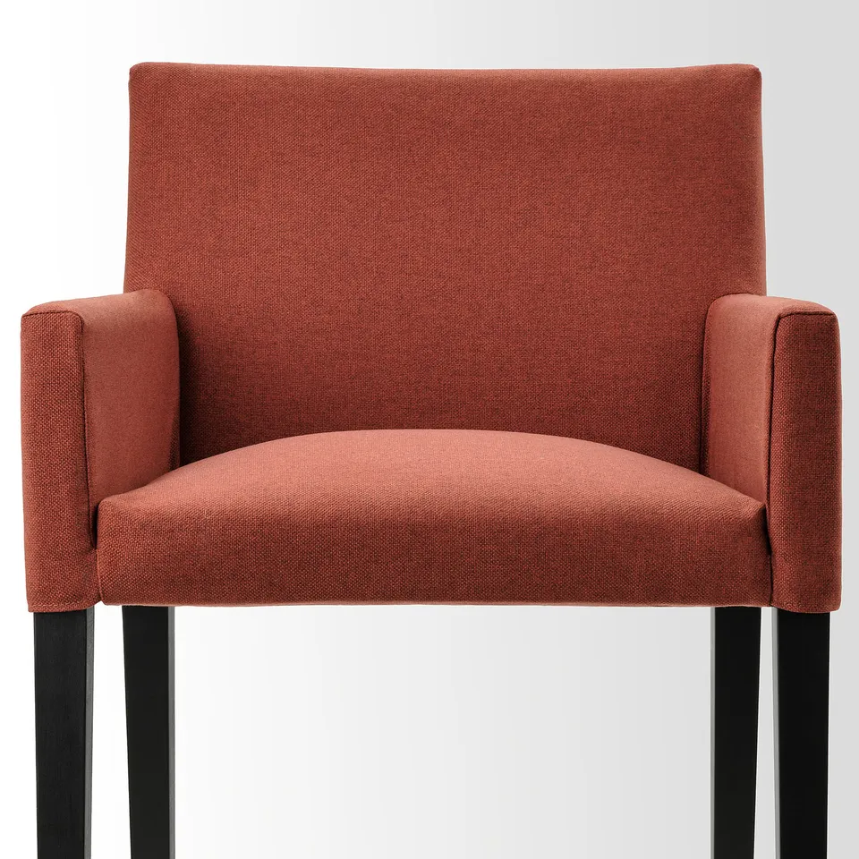 Stylish red upholstered chair with wooden legs, offering sofa-like comfort and quality.