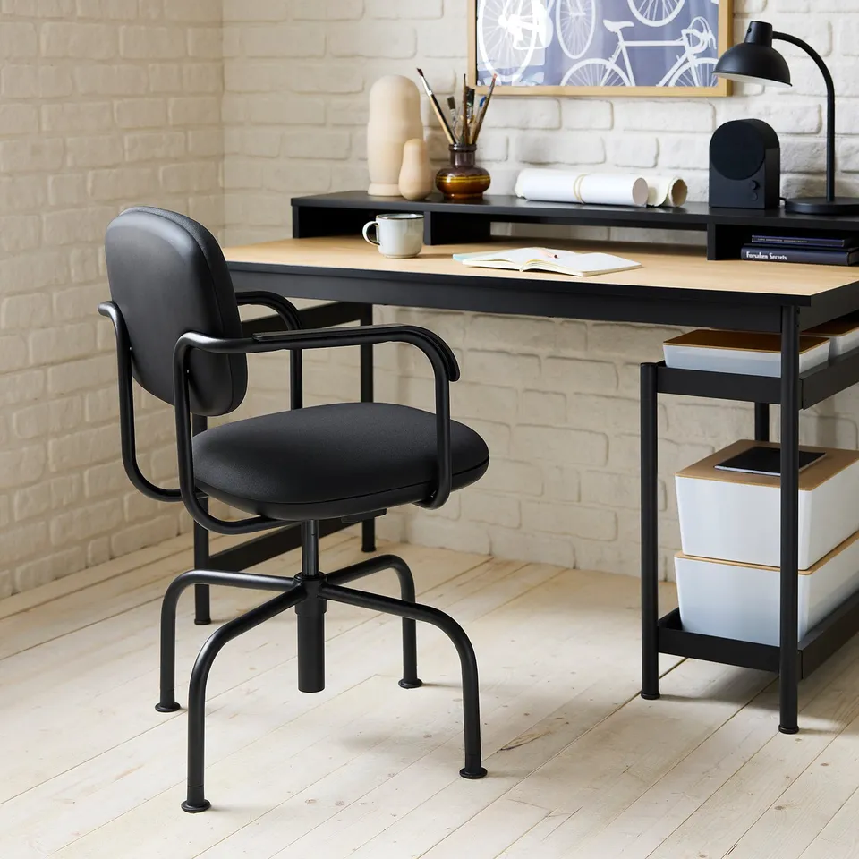 Home office with mullsjo desk & chair. Wood floor, white brick wall, stylish decor.