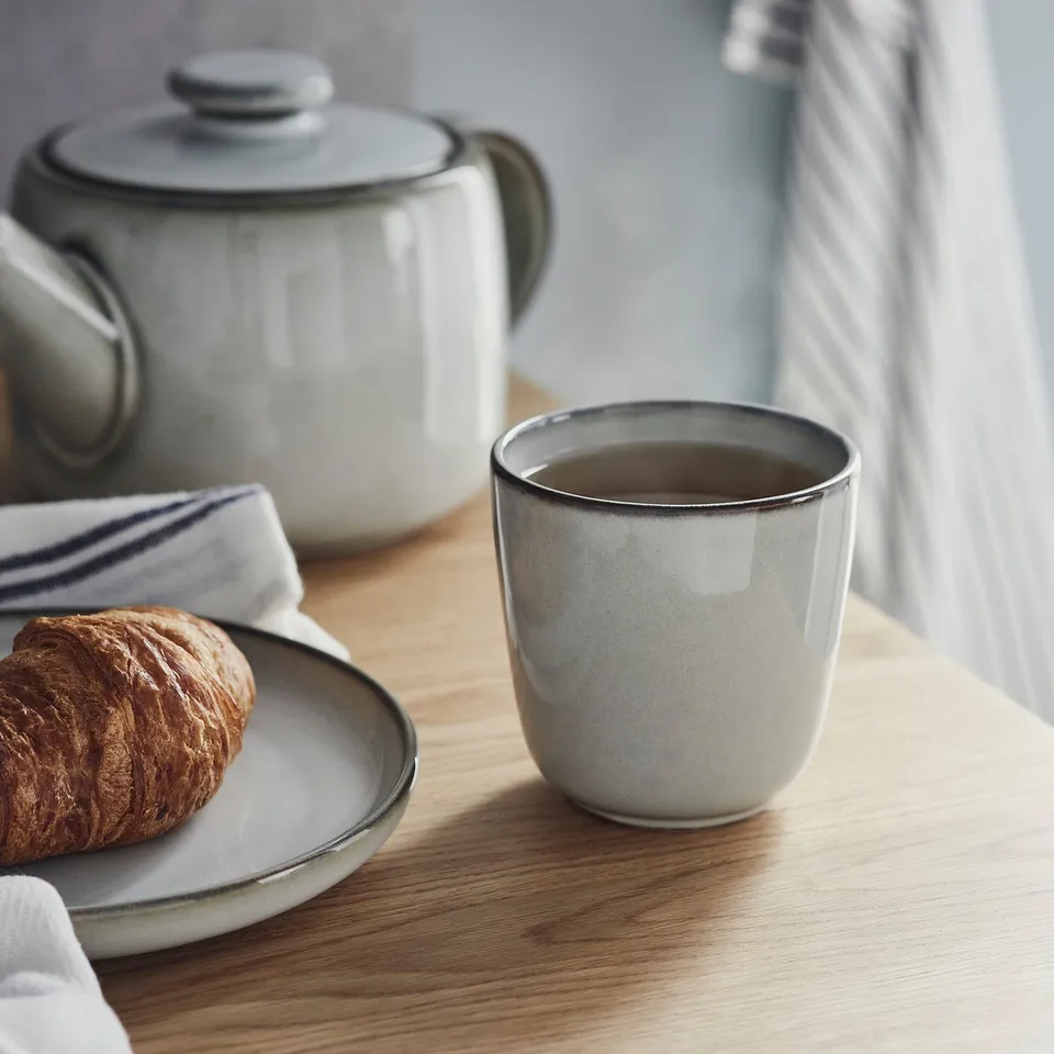 Ceramic mug with coffee, pastry, and teapot. GLADELIG series.