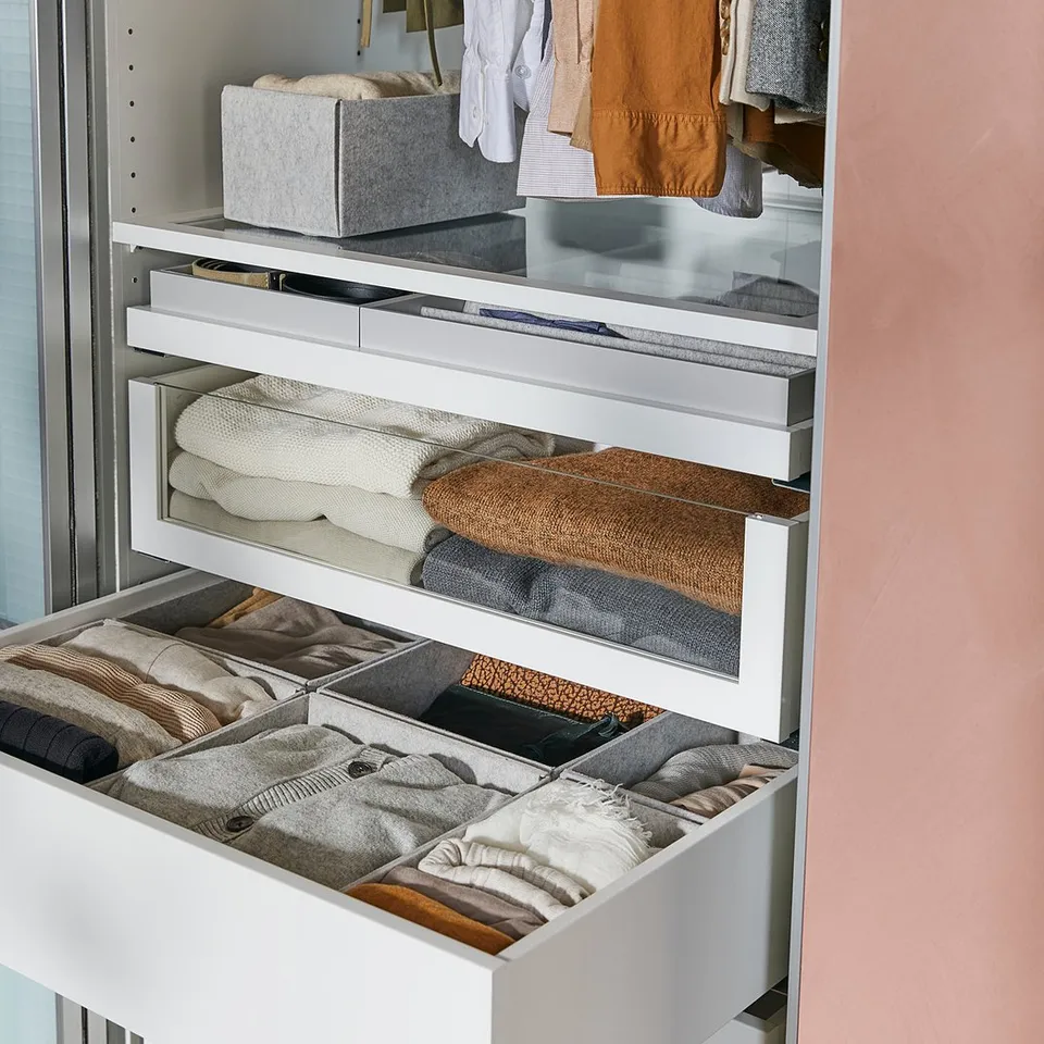 KOMPLEMENT white wardrobe drawer, neatly folded clothes, minimalist design.