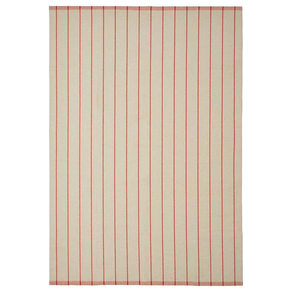 Displays a rectangular off-white rug named RIDSTIG with red stripes. Its soft, made from cotton, and designed for under dining tables.