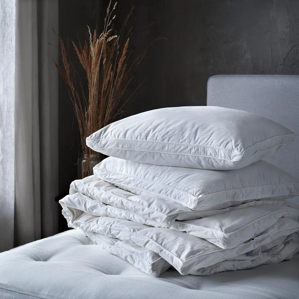 Ubble white duvet stack on bed; soft, stitched, down-filled comfort.