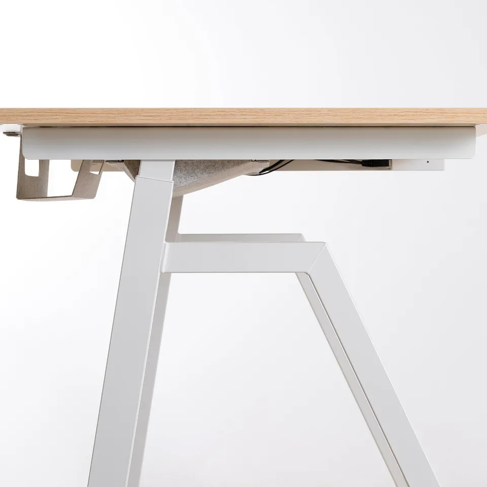 Modern adjustable height desk with light wood top and white metal frame.