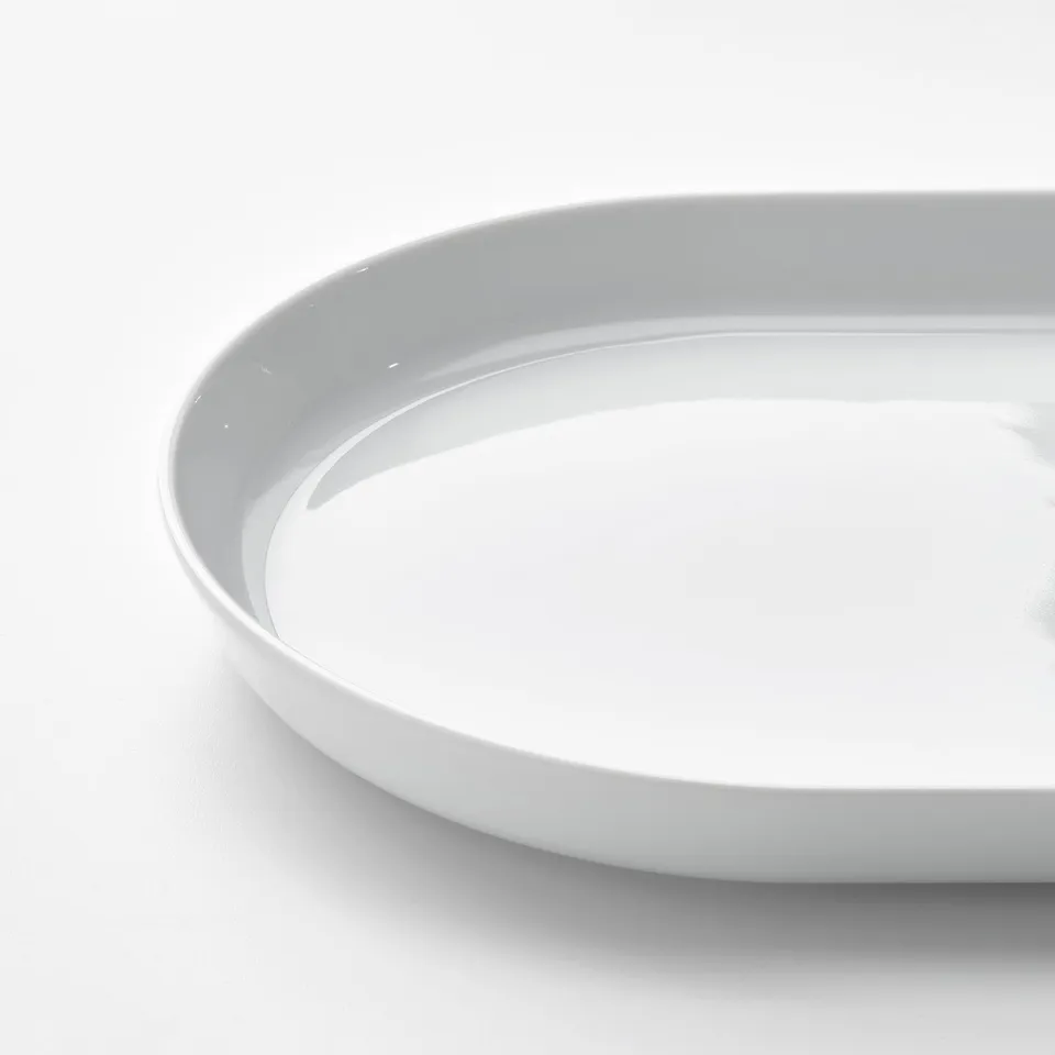 Smooth, white porcelain dish; stackable, durable, clean design.