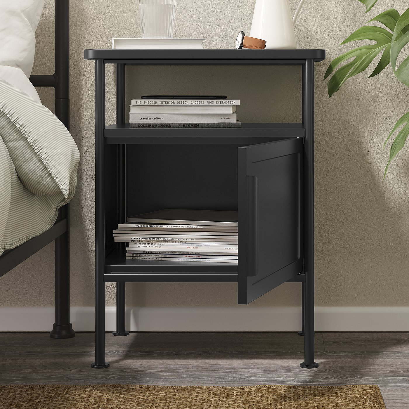 Black bedside table with books and a clock. Offers open storage on two levels and a cabinet with an adjustable door.