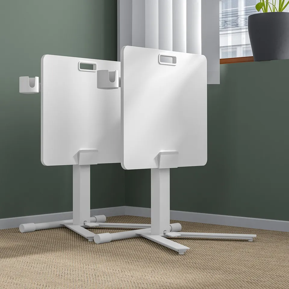 Two adjustable laptop tables with castors and tiltable tops in office setting.