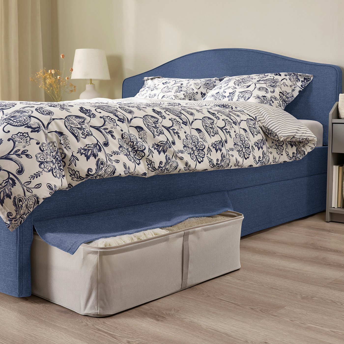 Bed with soft, curved headboard, removable cover, and under-bed storage.