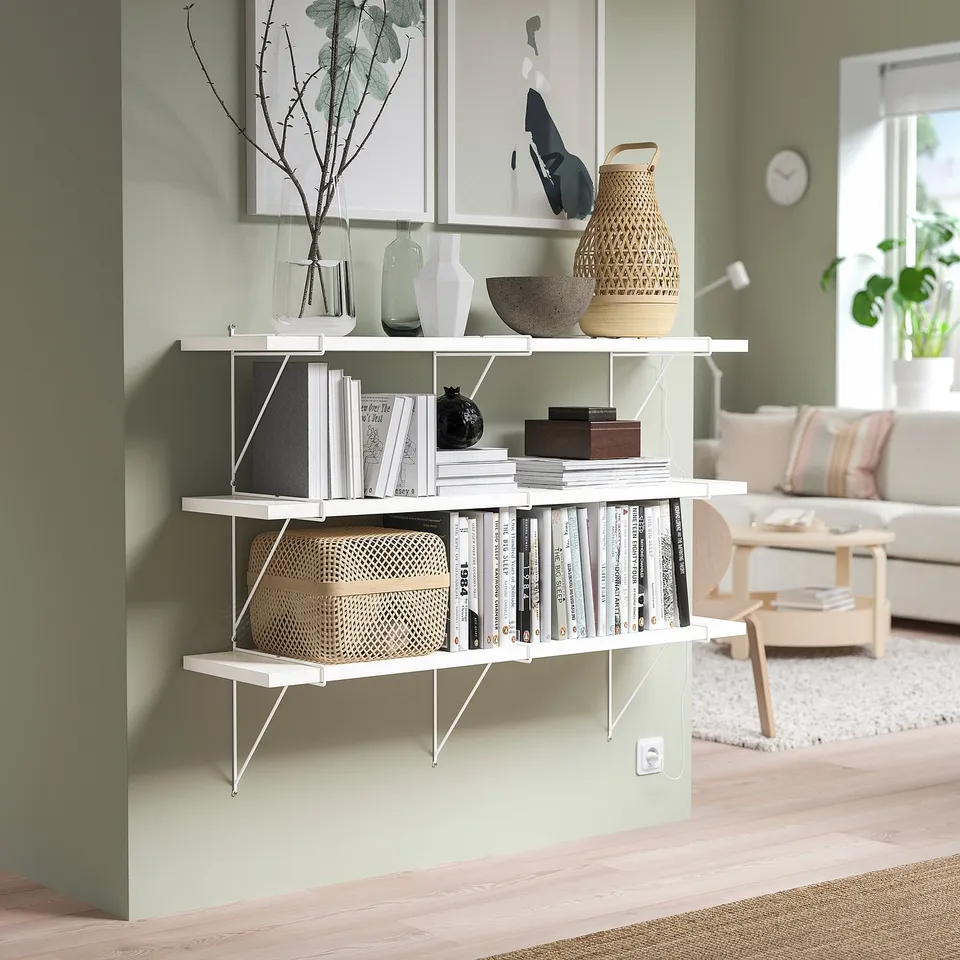 Modern living room with BERGSHULT wall shelf holding books, vases, and basket.