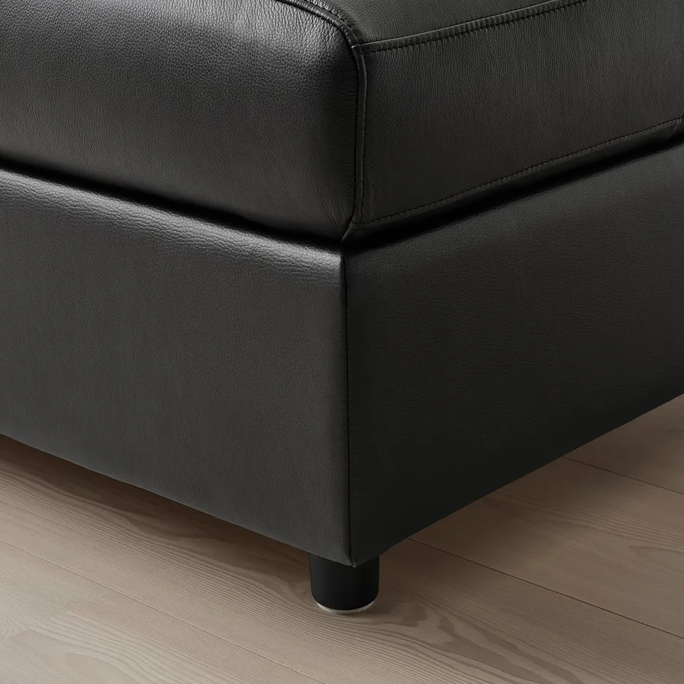 Black leather sofa corner, showcasing high-quality stitching and sleek design.