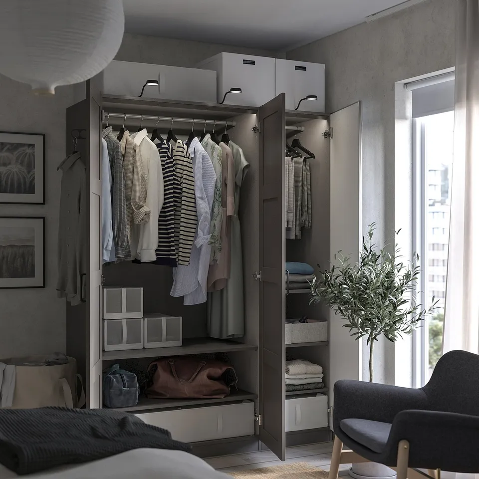 Open wardrobe with clothes and accessories, reflecting modern design with black and white colour scheme, located near a window.