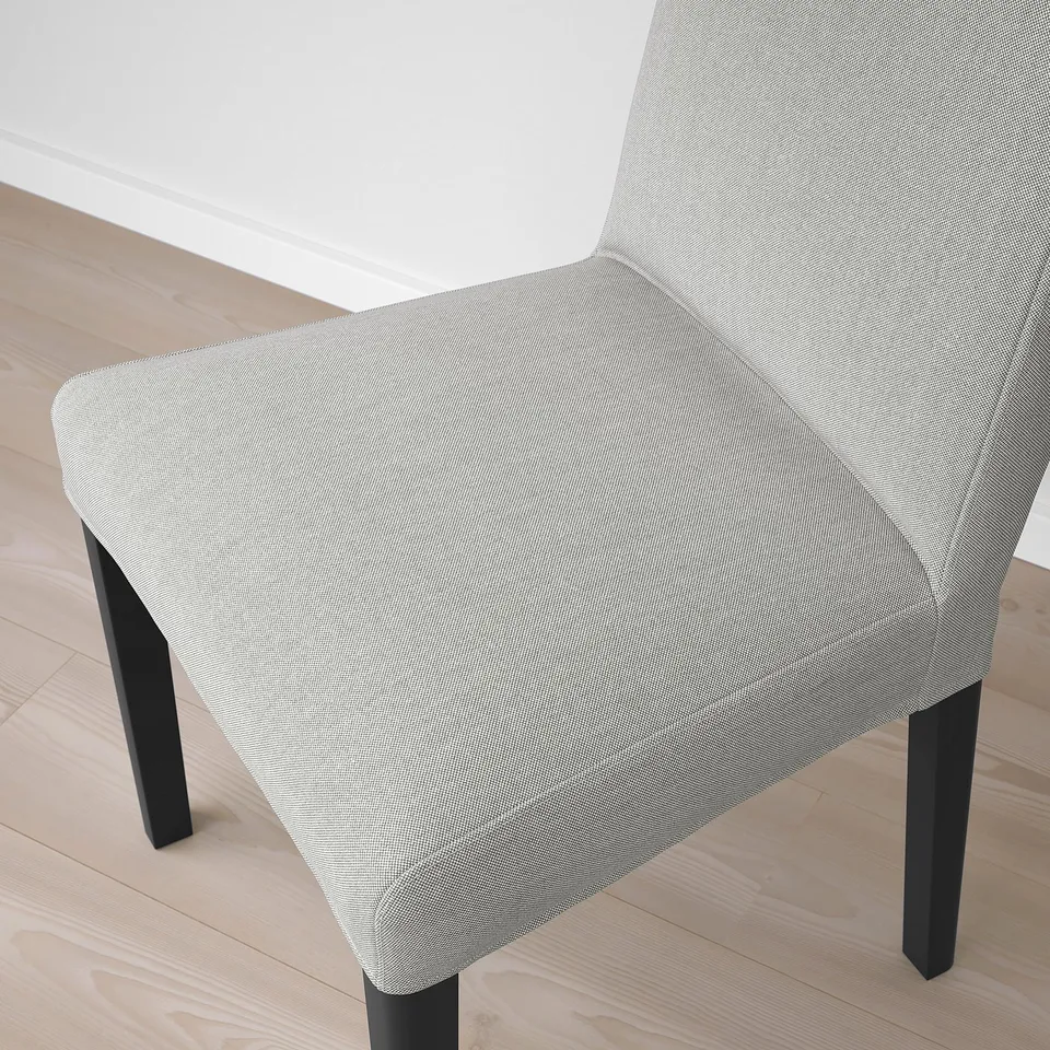 A modern dining chair with a sleek, grey upholstered seat and back, supported by sturdy black legs, showcasing high-quality design and comfort.