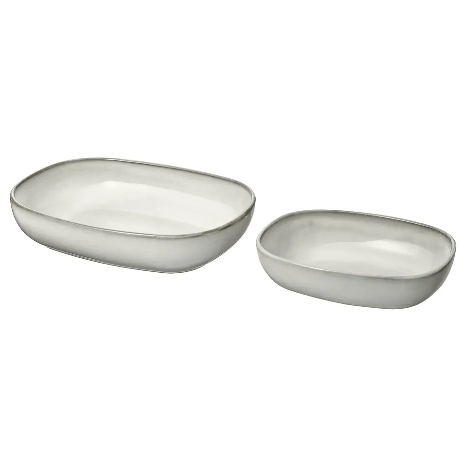 Two oval-shaped, sand-glazed ceramic serving dishes with sleek design.