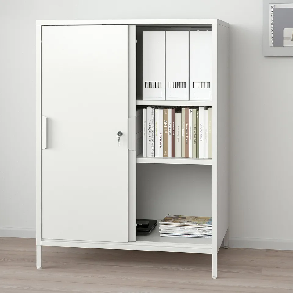 Double-sided TROTTEN cabinet with lockable doors, shelves for books, and natural light.