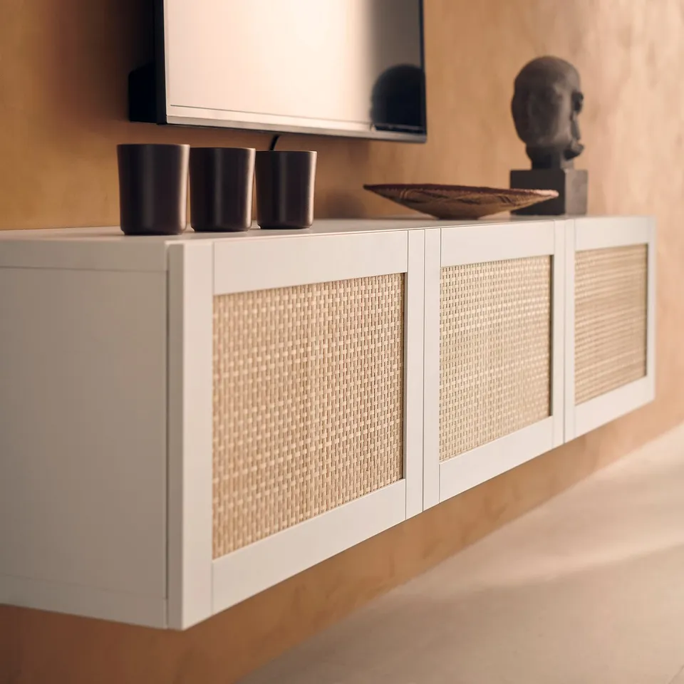 Modern white BESTÅ tv bench with woven fronts, black vases, decorative bowl, and sculpted head.