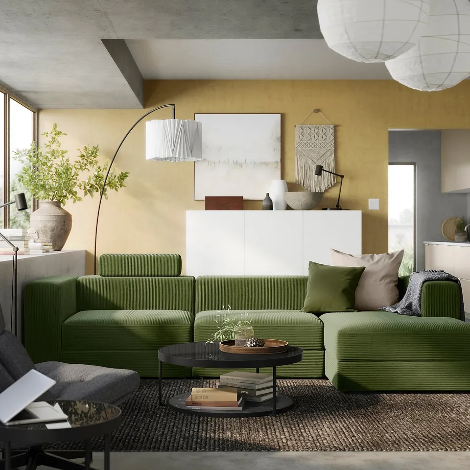 Modern living room with green JÄTTEBO sofa, yellow walls, boho decor, and minimalist lighting.