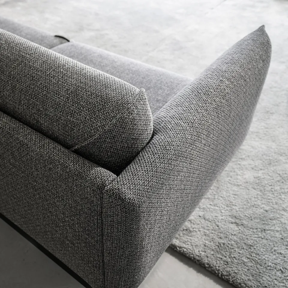 Modern grey sofa, corners visible. Sleek design, plush cushions. Comfortable, durable fabric.