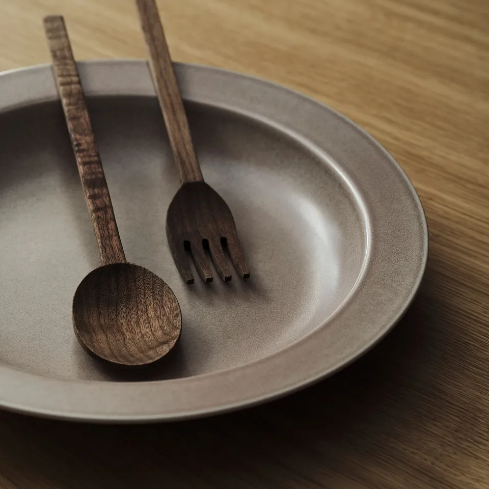 Elegant matte beige bowl with rustic wooden utensils, showcasing timeless quality and fine details.