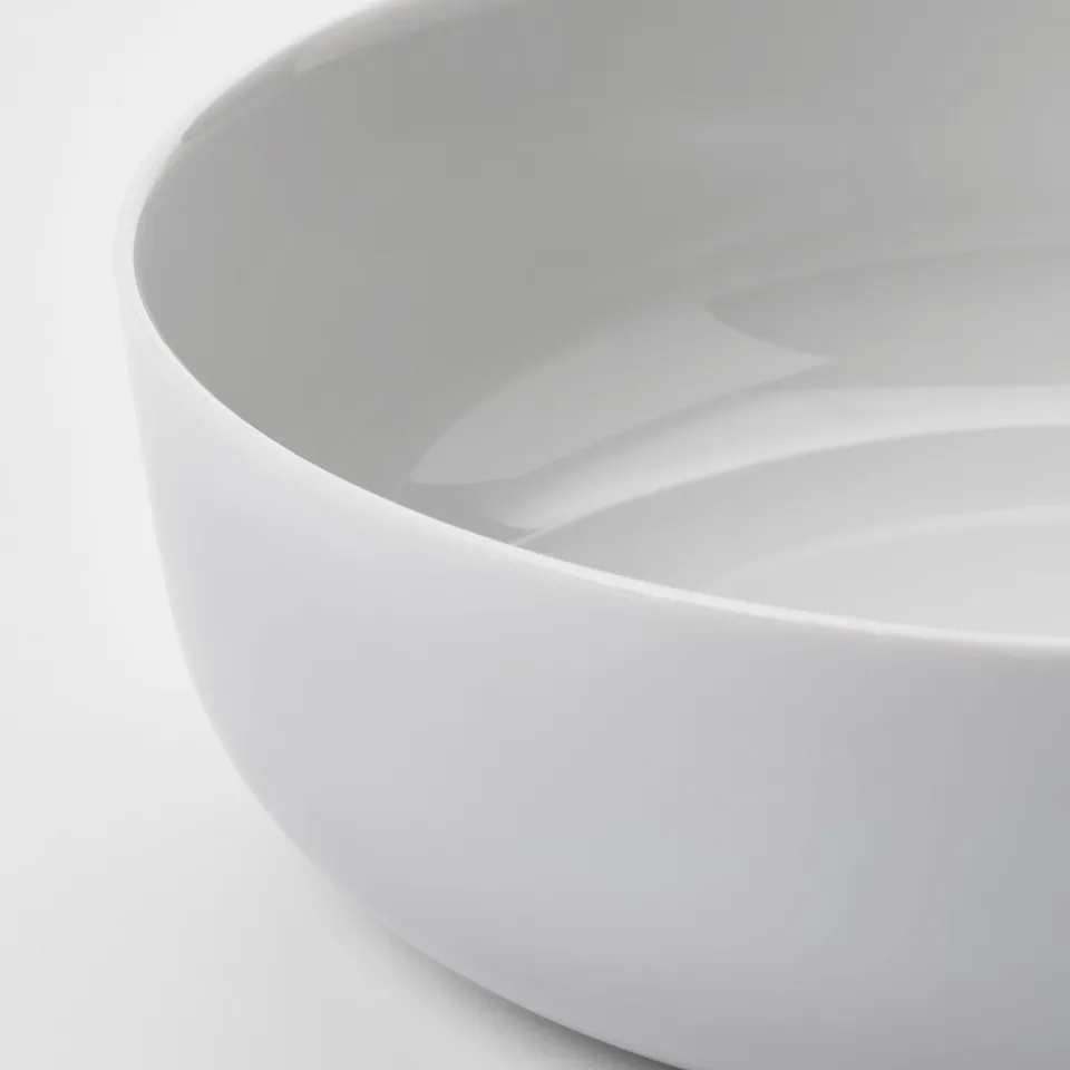 Sleek, white glass bowl with smooth edges, showcasing durability and elegant simplicity.