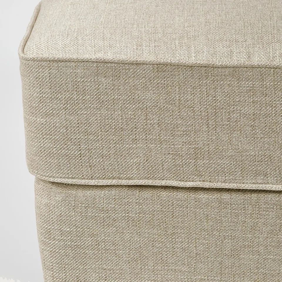 Upholstered footstool with detailed stitching, soft texture, and quality fabric.