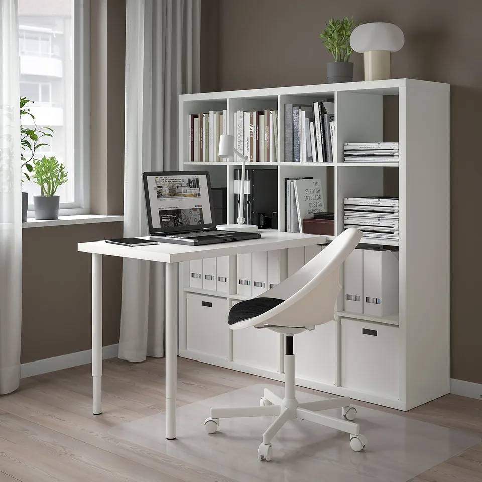 KALLAX shelf & desk setup with laptop, books, and chair.