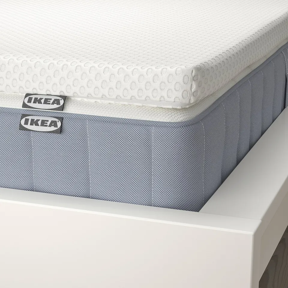 A close-up of a white ikea mattress on a white bed frame, showcasing its quality design and materials.