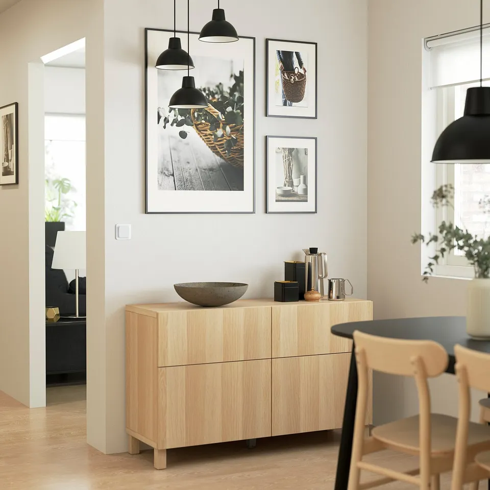 Modern dining room with BESTÅ sideboard, art, and pendant lamps.