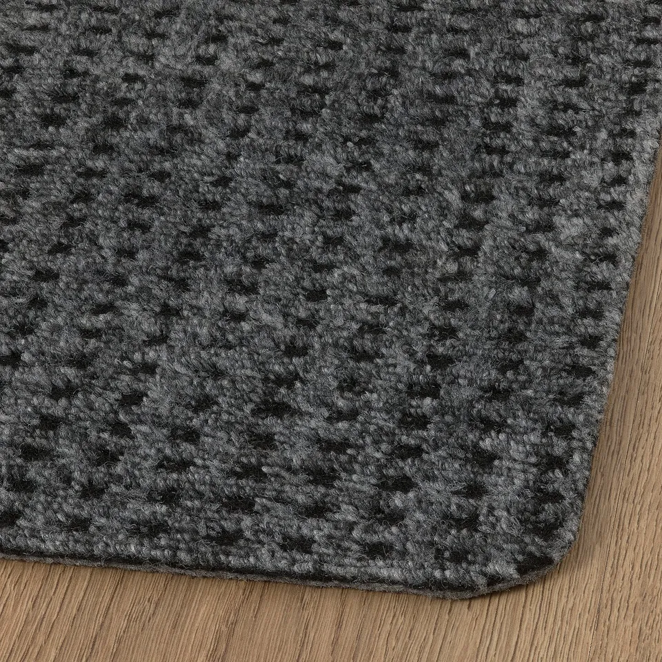 Door mat, textured grey pattern, durable material, rounded edges, placed on wooden floor.