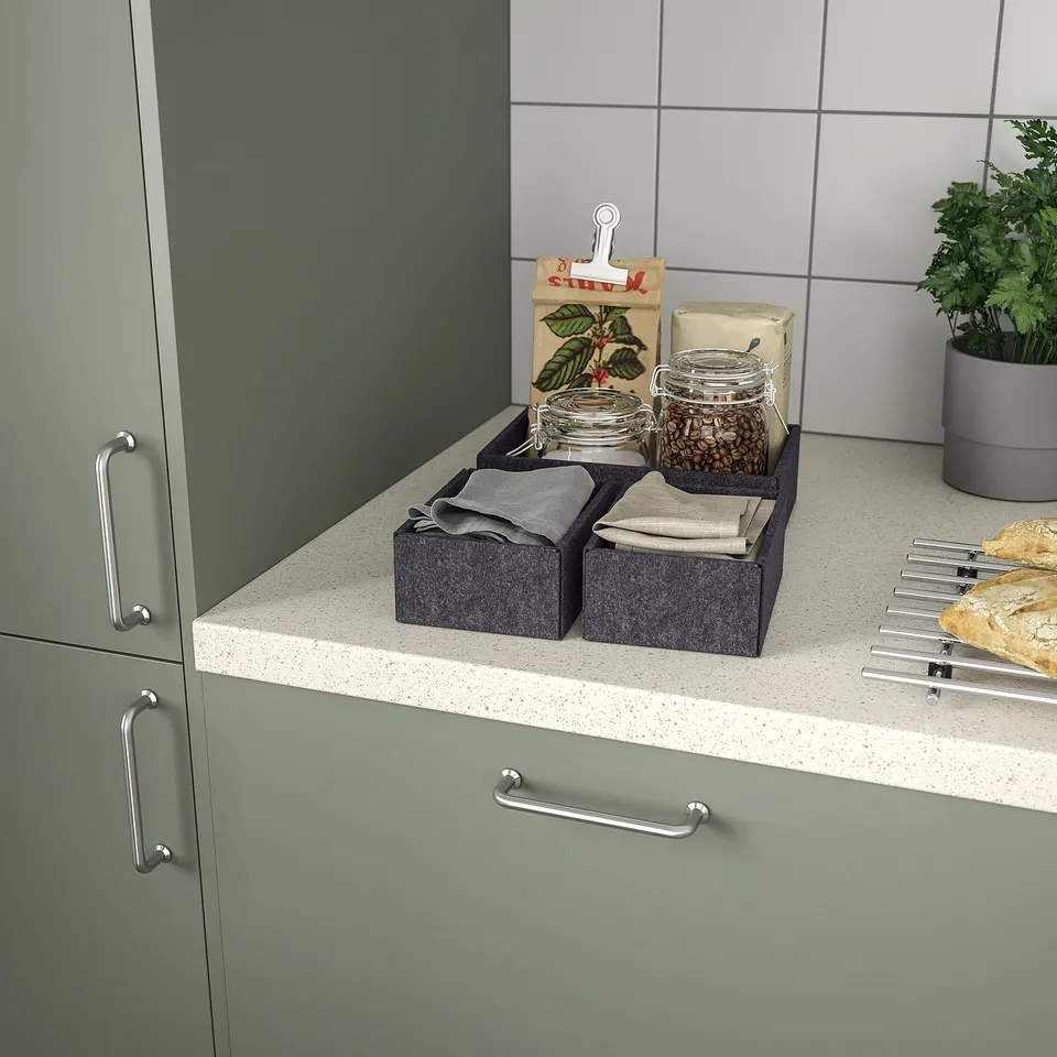 Kitchen counter with grey boxes, jars, and skewers.