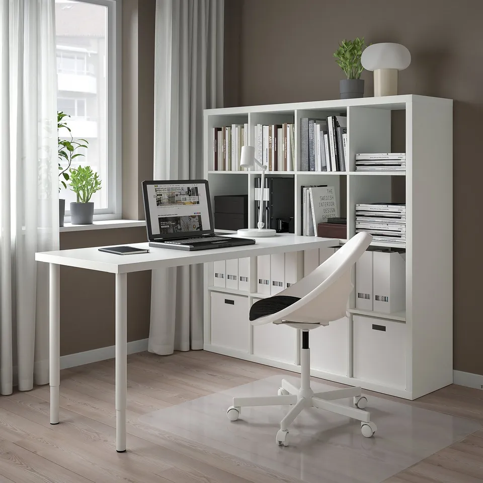 Home office with KALLAX shelves, laptop, plants, and office chair.