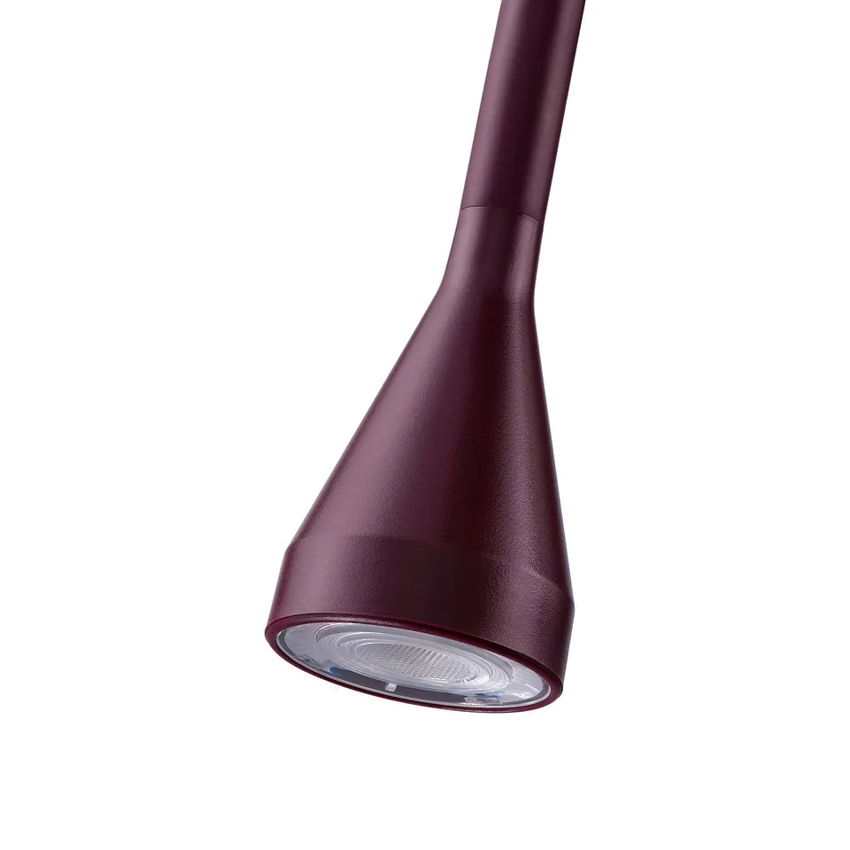 A sleek, modern, burgundy lamp with an adjustable neck and a focused light source.