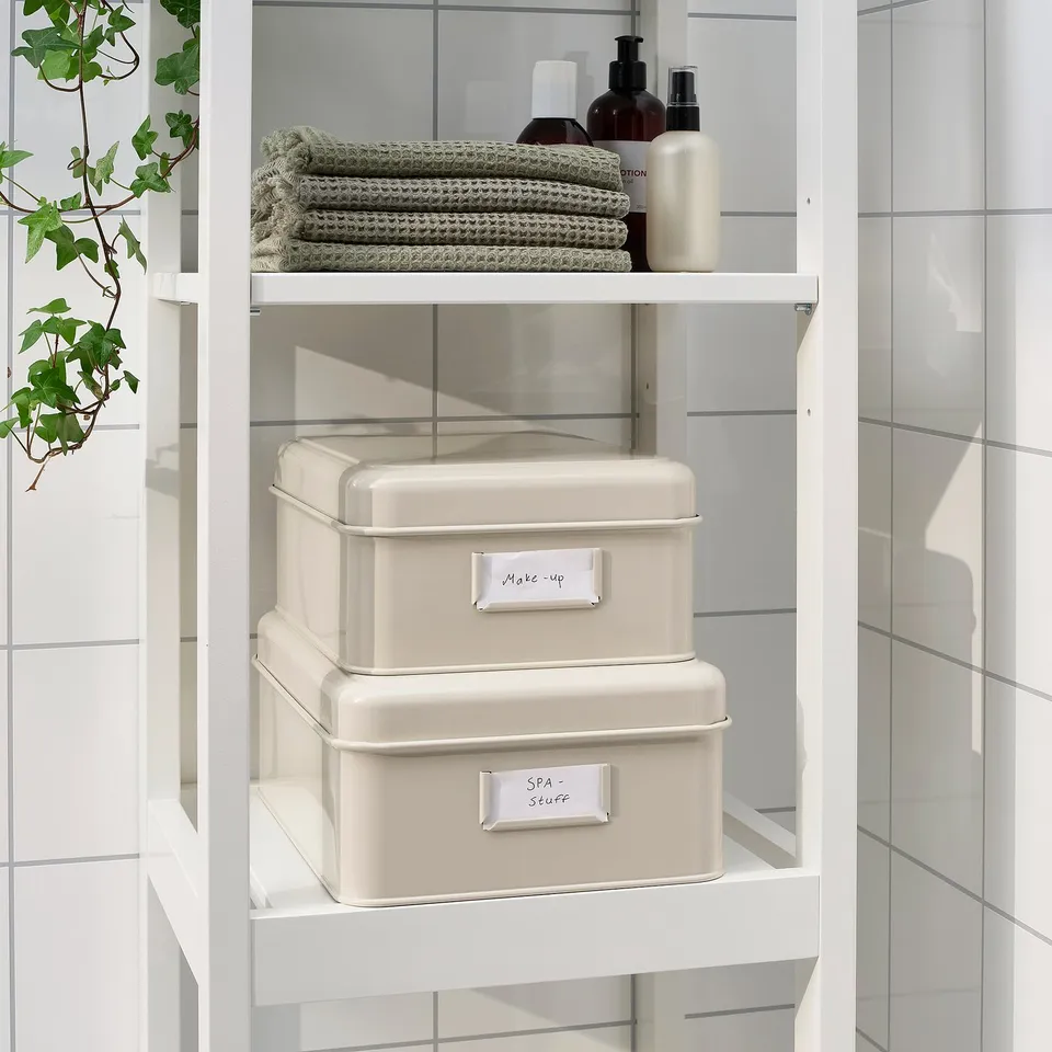 White metal storage boxes on bathroom shelf, labelled make-up and spa/scarf.