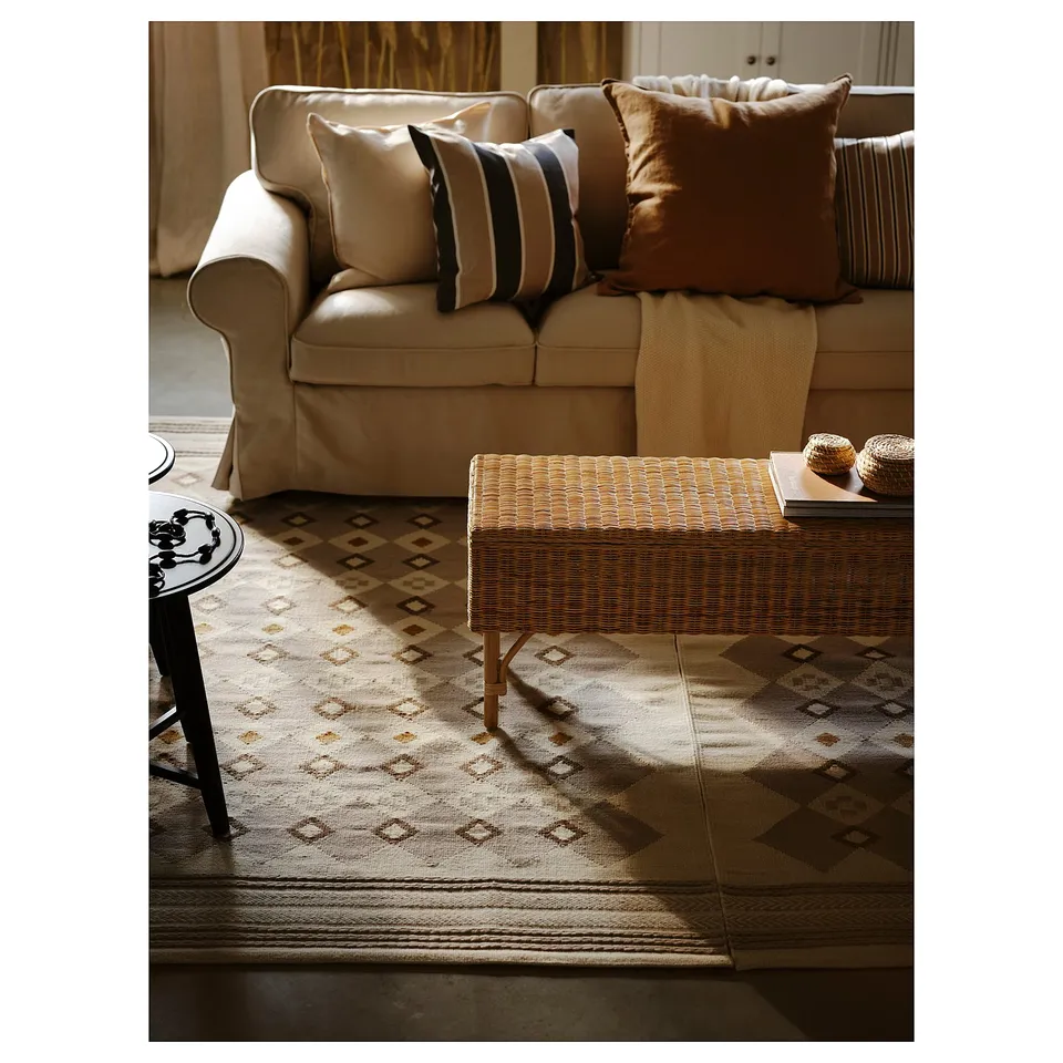 Neutral-toned, handmade wool rug with traditional patterns and soumak-weave borders, perfect for cosy living spaces.