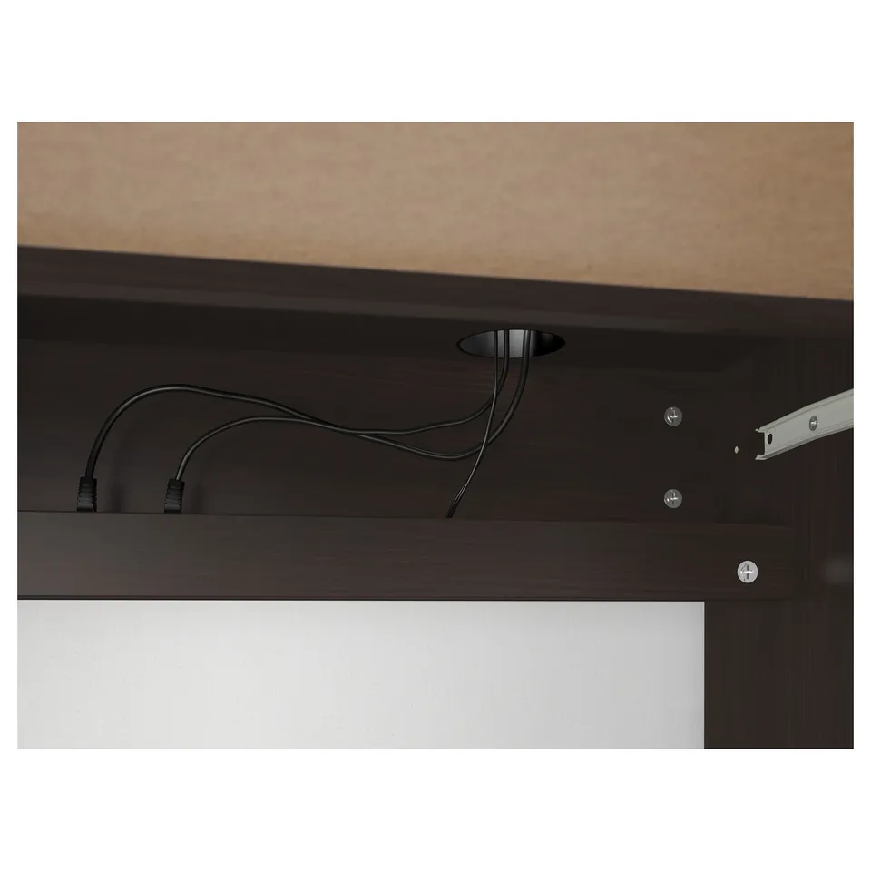 Dark desk shelf with visible cable management, showcasing organised wiring through a built-in outlet, emphasising neat storage and functionality.