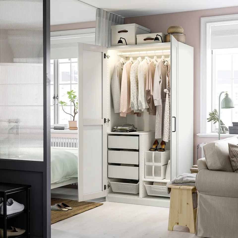 Room with classic PAX wardrobe, soft-close hinges, near window and sofa.