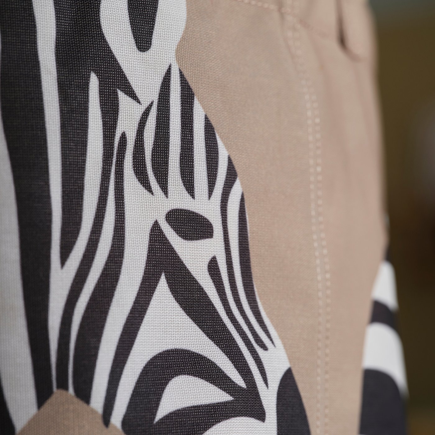 Close-up of durable, patterned storage bag with light beige accents. Shows intricate stitching and robust material.