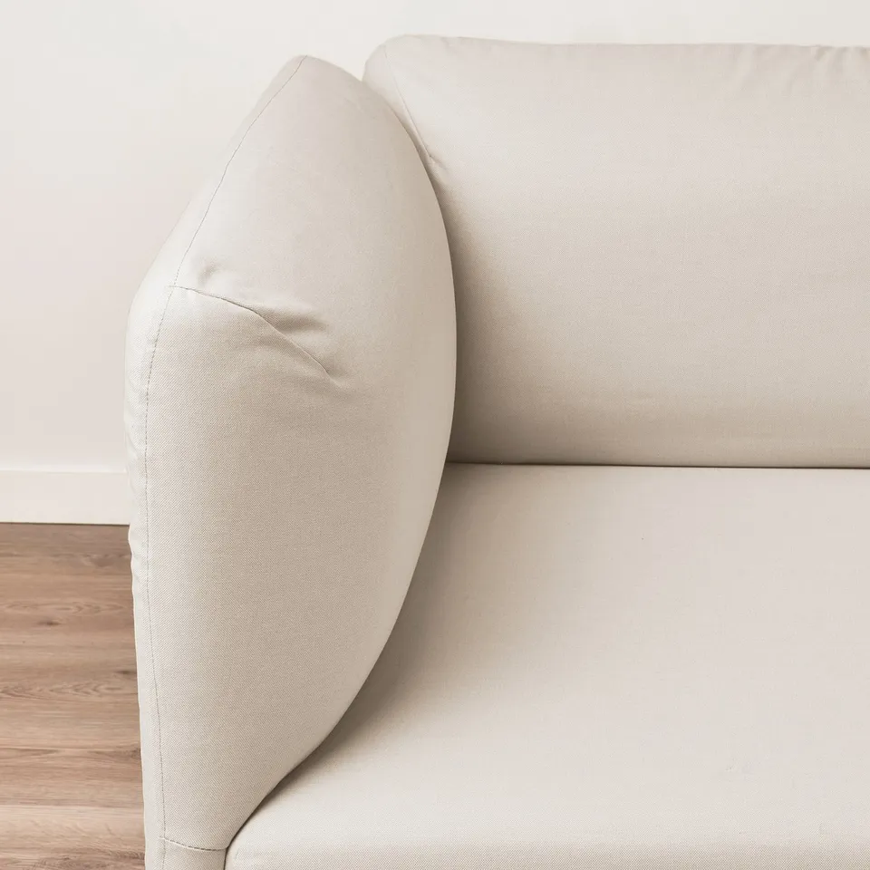 Modern beige sofa, clean lines, plush cushions.