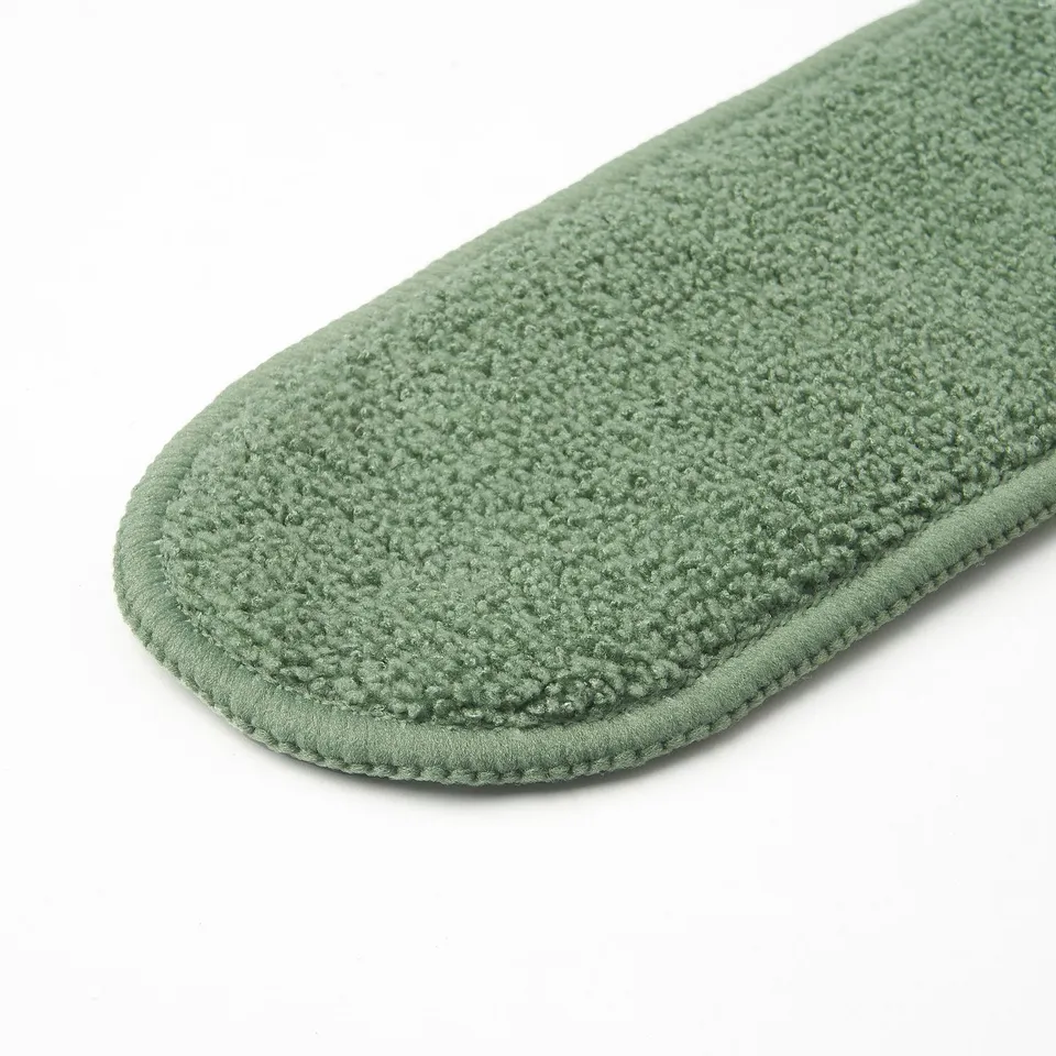 Close-up of green microfiber duster cover, soft texture, with stitched edges.