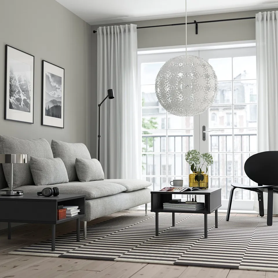 Minimalist living room with TUNSTA coffee table, striped rug, and pendant light.