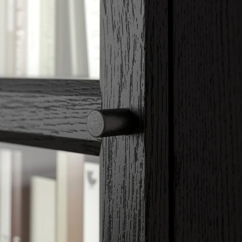 Close-up of black wooden bookcase with cylindrical metal handle, showing quality texture and finish.