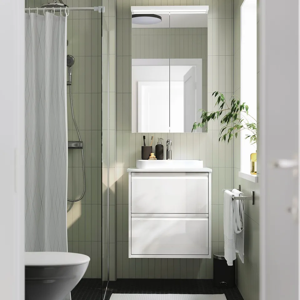 Modern bathroom with ÄNGSJÖN wash-stand, minimalist design, marble basin, plant by window.