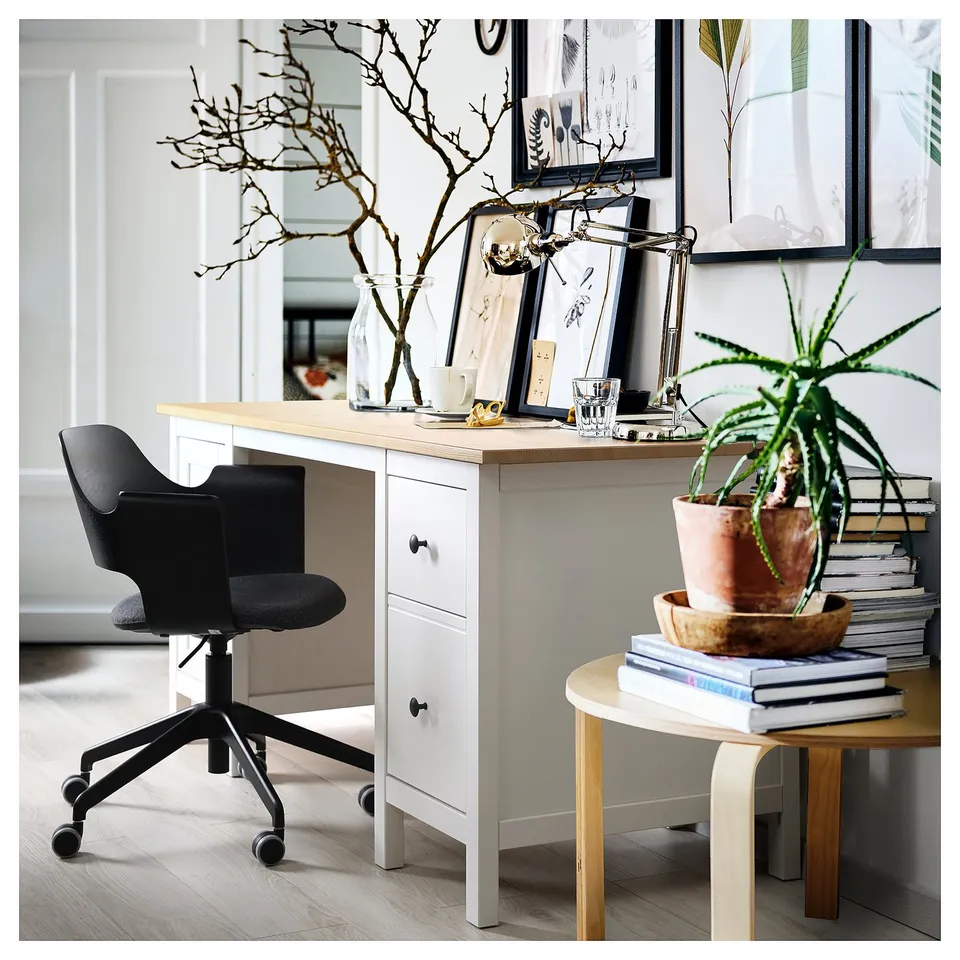 Home office: white desk, black chair, wooden top, drawers, plant, books, decorations.