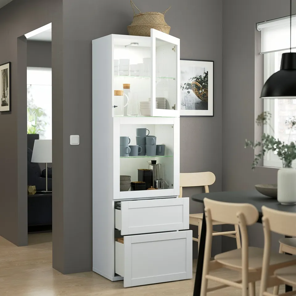 BESTÅ cabinet with glass doors displays mugs & jars in modern home decor.
