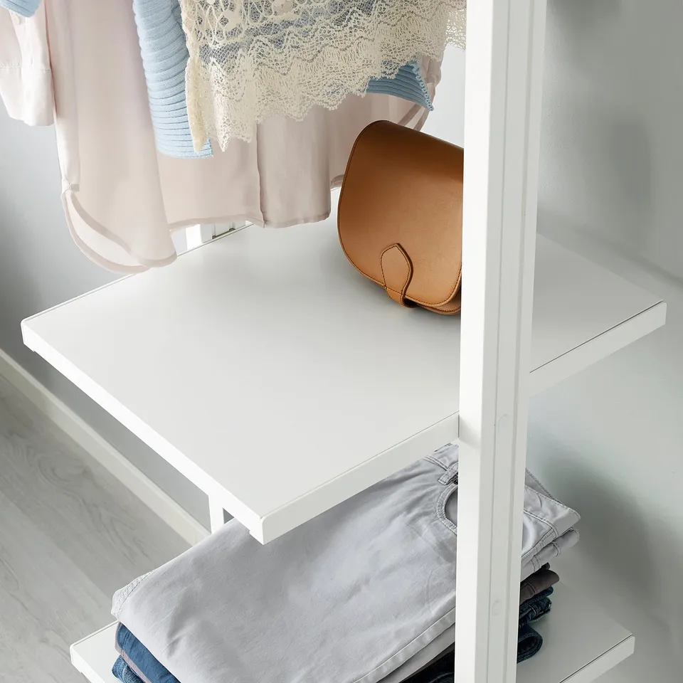 White ELVARLI shelf holding brown purse, folded clothing, and hanging garments.